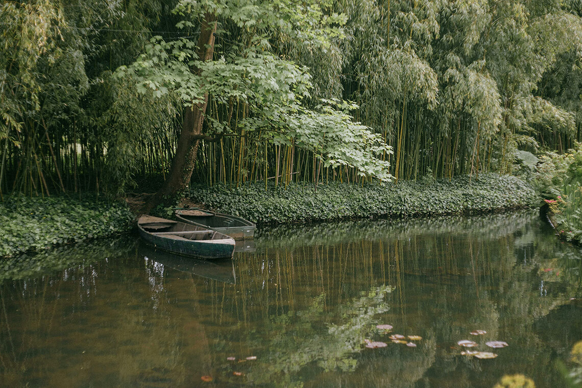 Dos barcas en un canal sombreado por árboles y vegetación densa — ejemplo de adaptación climática urbana mediante integración de agua, sombra y biodiversidad